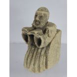 An Antique Stone Carving of a Franciscan Monk, depicted seated reading from the Bible, approx 10