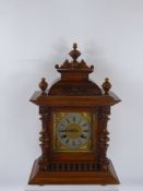 An Edwardian Carved Oak Cased Mantel Clock, the clock having a stamped Junghans chiming movement