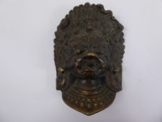 An Antique Bronze Indian Mask, depicting a deity, the deity depicting snakes and sculls in the