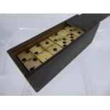 A Early 20th Century Bone and Ebony Dominoes Set, complete with playing pieces.