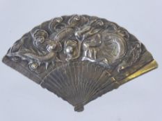 A Chinese Wang Hing Silver Clip, in the form of a fan, carved with chasing dragons amongst cloud