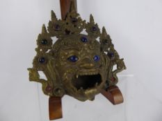 A Tibetan Incense Burner, depicting the mask of Mahakala on tripod base, with blue glass to eyes and