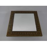 An Edwardian Arts and Crafts Mirror, the mirror having bevelled glass with brass frame depicting