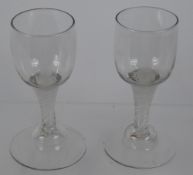 A Pair of 18th Century Ribbon Glasses, with a round funnel bowl, ribbon stem on conical foot, height