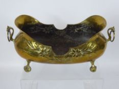 A Brass Art Nouveau Style Slipper Jardiniere, embossed with flowers, raised on ball and claw feet.