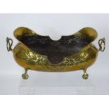 A Brass Art Nouveau Style Slipper Jardiniere, embossed with flowers, raised on ball and claw feet.