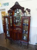 An Ornate Late Victorian Inlaid Display Cabinet, circa 1900, having glazed doors to either side with