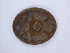 A Small WWII Bronzed Oval Badge, depicting crossed swords and helmet with swastika emblem, awarded