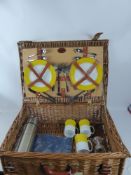 A Wicker Picnic Basket, comprising four napkins, a metal thermos flask, three mugs, four medium size