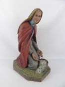 A Victorian Hand-Painted Pastoral Figure of a Nun. The Nun kneeling on grass with a picnic basket on