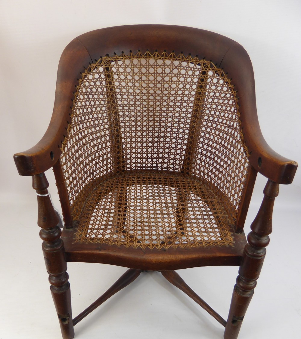 A Child's Oak and Wicker Chair, with cross stretchers and swept arms.