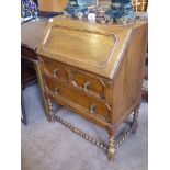 A Small Oak Drop-Front Writing Desk, fitted interior, with two drawers, raised on barley-twist