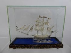 A Silver Filigree Model of a Sailing Ship, housed within a square glass cover and presentation box.