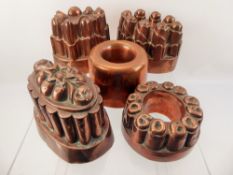 Seven Vintage Copper Jelly Moulds, of various designs, together with a brass jam pan with cast