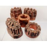 Seven Vintage Copper Jelly Moulds, of various designs, together with a brass jam pan with cast