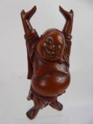 A Carved Wooden Figure of Hotei, with ivory teeth and eyes, approx 17 cms