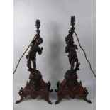 A Pair of Late 19th Century Bronzed Lamps Depicting Standing Cherubs, raised on a red marble base