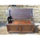 A Carved Mahogany Monk's Bench, with lion supports, storage cupboard beneath, label reads "Collyer's