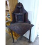 A Mahogany Carved Corner Table, with small cupboard atop and two shelves, approx 53 x 53 x 130