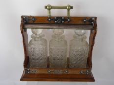 A Oak Cased Tantalus, with three cut glass decanters.