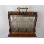 A Oak Cased Tantalus, with three cut glass decanters.