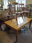 A Pine Kitchen Table, approx 150 x 90 cms, on turned legs together with four pine Reach chairs and