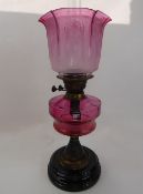 An Antique Cranberry Glass Oil Lamp, the lamp having etched glass shade, total ht 57 cms.