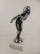 A White-Metal Bonnet Ornament, in the form of a girl diver, raised on a white marble plinth,