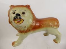 A Staffordshire Mantel Figure, in the form of lion with glass eyes, approx 39 cms in length.