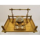 A Brass Ink Stand, the stand having one lidded glass inkwell, on a stand with three sets of pen