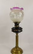 A Victorian Hand Painted Brass Oil Lamp, with cranberry-style etched glass shade, approx 67 cms.