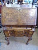 A Lady's Walnut Writing Desk, with fitted interior and three drawers, on cabriole feet.