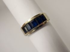 A Lady's 14 k White Gold and Sapphire Ring, the ring of channel set design with four emerald cut