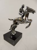 A Chrome-Plated Bonnet Ornament, in the form of a jump jockey, raised on a square granite base,