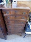 A Mahogany-Effect Chest of Drawers, the graduated drawers having an inlaid front on bracket feet,