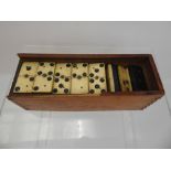 A Dominoes Set, made of bone and ebony in a wooden box without lid.
