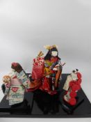 Three Vintage Hand-Made Japanese Geisha Dolls on Black Lacquer Plinths together with a small