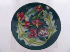 A Moorcroft Round Pin Dish, depicting Tiger Lilies and others on green ground, 1995, approx 12