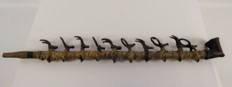 An Antique Benin Bronze and Snakeskin Figural Pipe, the pipe wrapped in snake skin with ten stylized