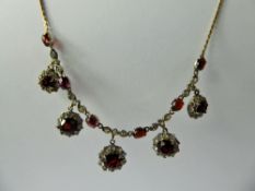 An Antique 9 ct Garnet & White Stone Necklace, the necklace set with five graduated garnets in