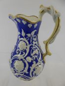 A Small Blue-Glazed Jug Decorated with white moulded flowers and white serpent to the handle,