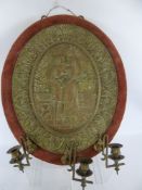 A Pair of Victorian Brass Candle Sconces, each mounted to a brass repousse work plaque depicting