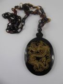 A Tortoiseshell Mirrored Pendant (Chinese), depicting a dragon (testing as natural and not