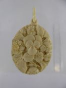 A Delicate Antique Ivory Mourning Pendant, hand carved with flowers, the inside with plaited hair