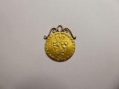 An 1796 George III Spade Guinea, the coin having a rose gold mount, approx 8.6 gms.