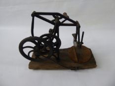 A Victorian Wrought Iron Kitchen Aid, supported on a wooden base.