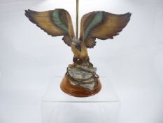 A Brass and Ceramic Lamp Base, depicting an eagle with wings held aloft, on circular base, approx 32