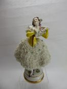 A German Porcelain Figurine, with delicate lace-work dress, factory marks to base, approx 30 cms.