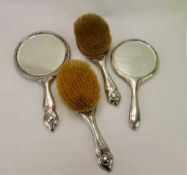 A Three-Piece Silver Brush Set, including two hair brushes and mirror together with another single