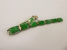 A Chinese White Metal Bright Green Jade Bracelet, the bracelet having ten carved segments approx